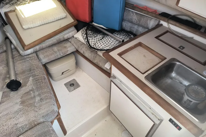 Slide: The Image of 1995 Robalo 2440 Walkaround cabin interior with kitchenette and seating area. - 12