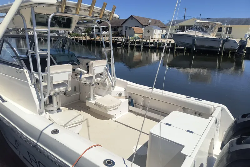 Slide: The Image of 1995 Robalo 2440 Walkaround boat docked, featuring spacious cockpit and dual seating. - 3