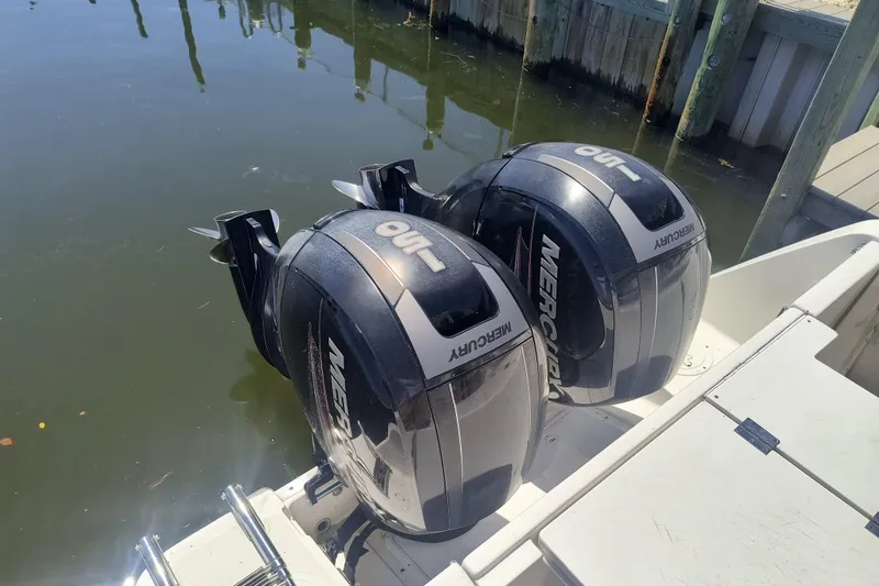 Slide: The Image of Twin Mercury outboard engines on a 1995 Robalo 2440 Walkaround boat at dock. - 5
