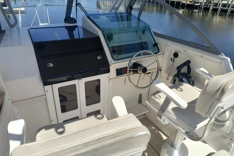 Slide: The Image of 1995 Robalo 2440 Walkaround boat cockpit with steering wheel and seating. - 7