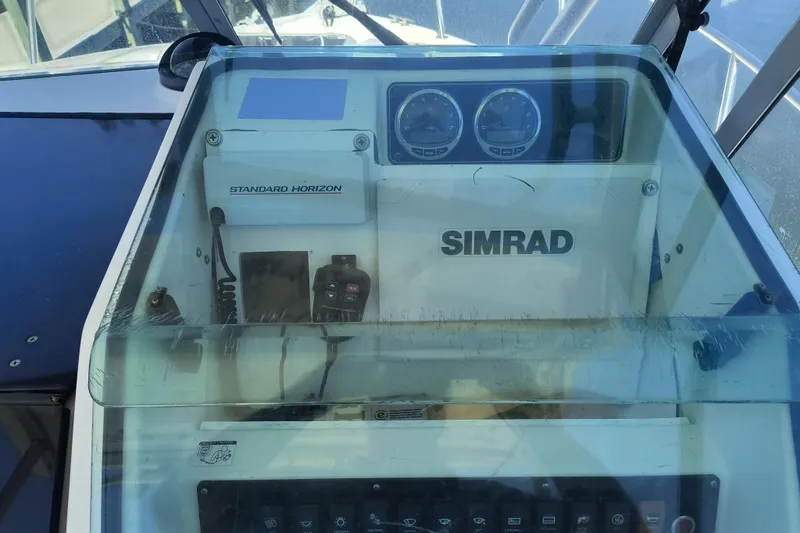 Slide: The Image of 1995 Robalo 2440 Walkaround boat dashboard with Simrad and Standard Horizon equipment. - 9