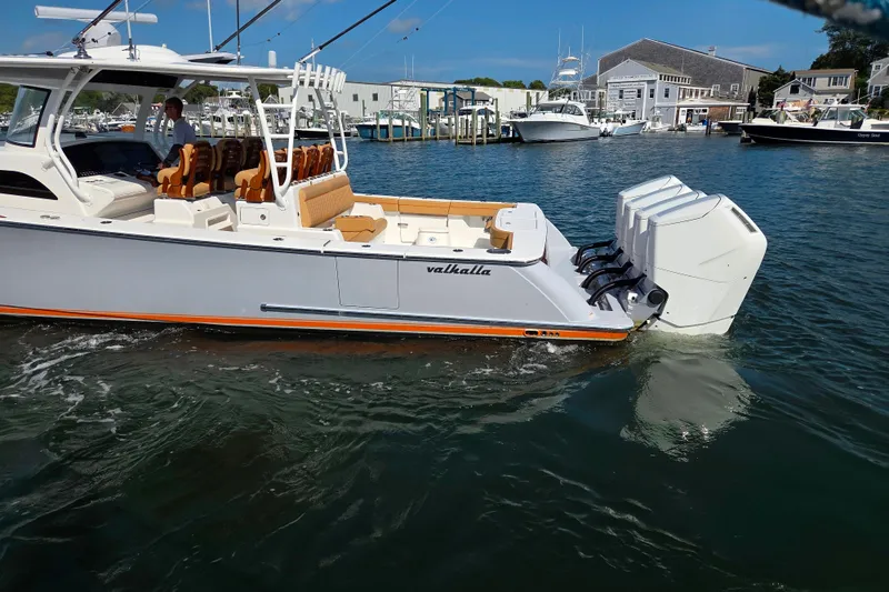 Slide: The Image of 2023 Valhalla Boatworks V-46 cruising in a marina, showcasing sleek design and powerful engines. - 19