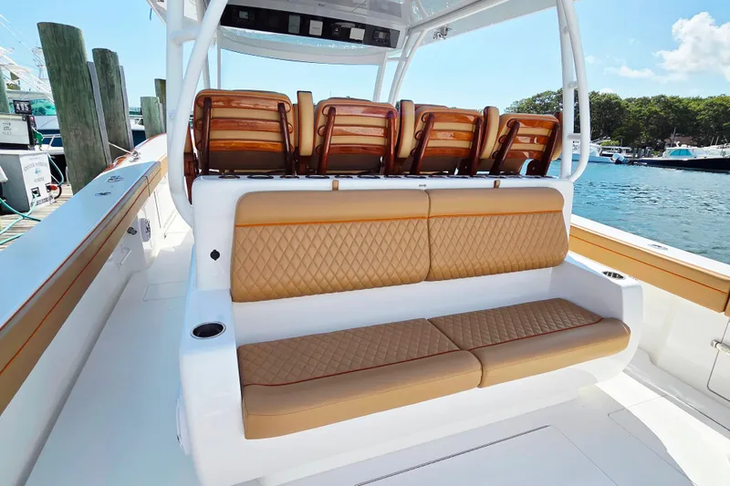Slide: The Image of 2023 Valhalla Boatworks V-46 interior with tan quilted seating, docked by the water. - 29