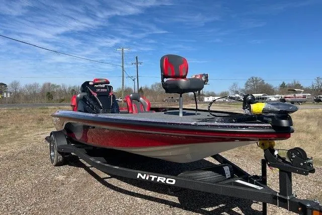 Slide: The Image of 2025 Nitro Z19 boat on trailer, red and black design, parked outdoors. - 18
