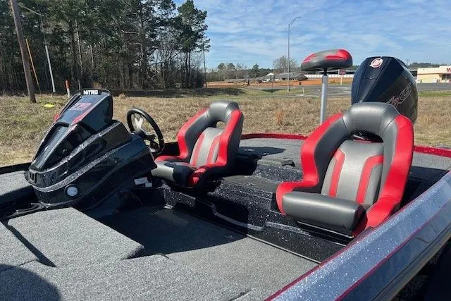 Slide: The Image of 2025 Nitro Z19 boat with red and gray seats, parked outdoors. - 3