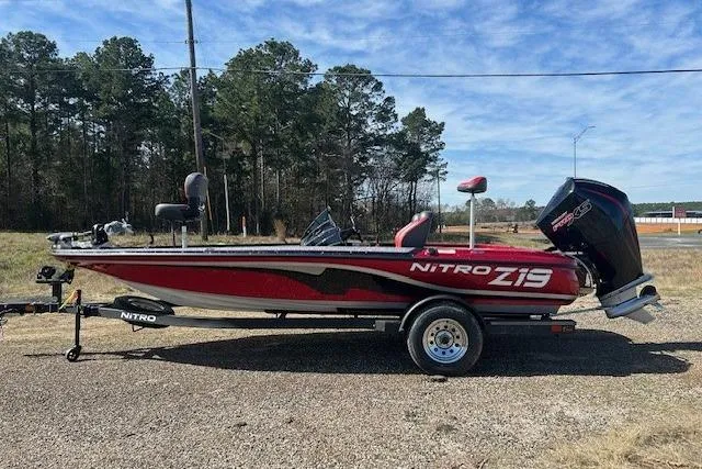 Slide: The Image of 2025 Nitro Z19 boat on trailer, red and black design, parked outdoors. - 5