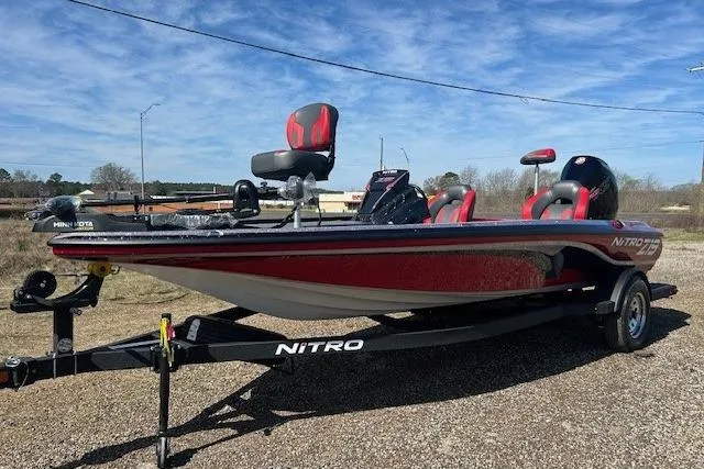 Slide: The Image of 2025 Nitro Z19 boat on trailer, red and black design, parked outdoors. - 8