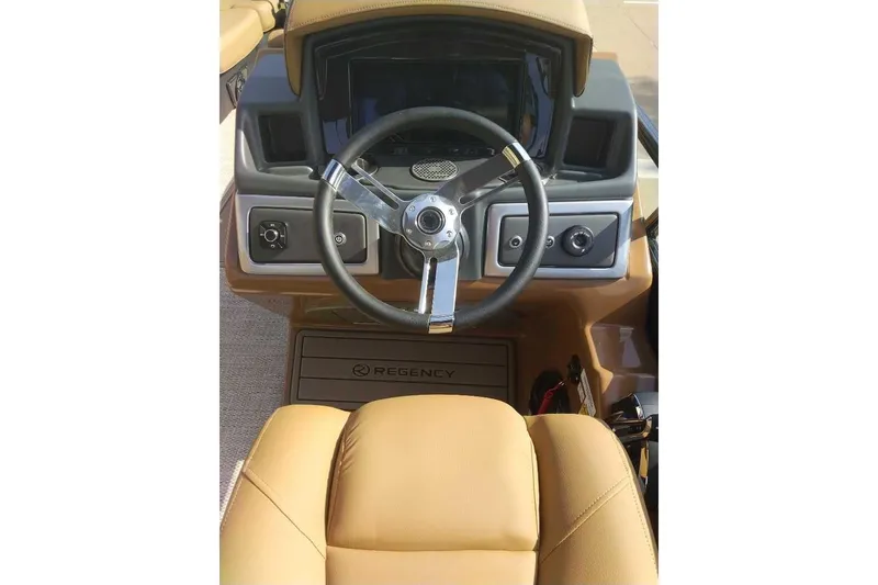 Slide: The Image of 2025 Regency 250 LE3 Sport boat dashboard with steering wheel and controls. - 2