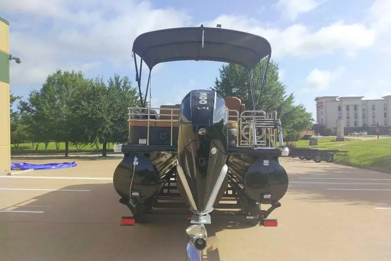 Slide: The Image of 2025 Regency 250 LE3 Sport pontoon boat with powerful outboard motor in parking lot. - 3