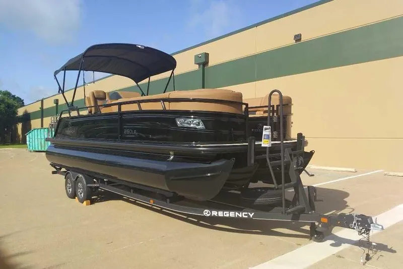 Slide: The Image of 2025 Regency 250 LE3 Sport pontoon boat on trailer, parked outdoors. - 5