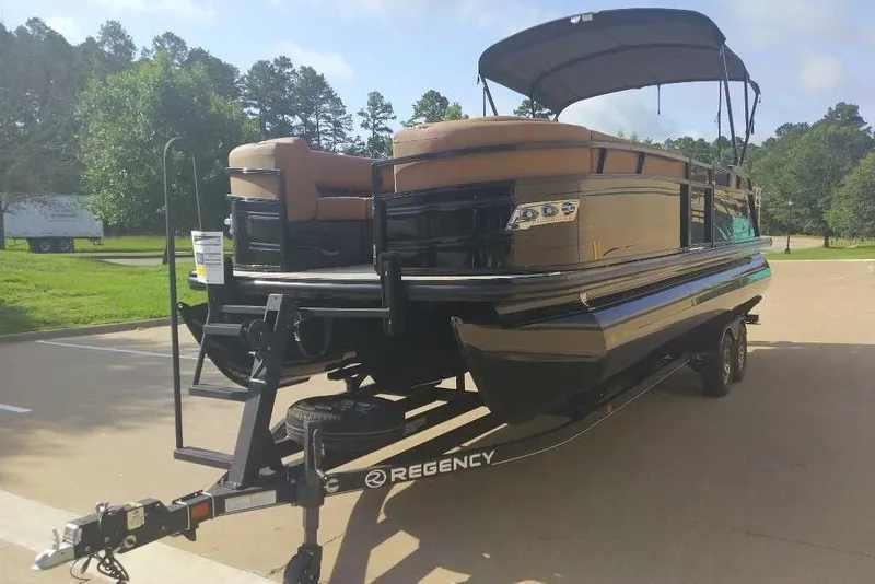 Slide: The Image of 2025 Regency 250 LE3 Sport pontoon boat on trailer in sunny parking lot. - 7