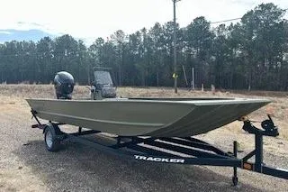 Slide: The Image of 2025 Tracker Grizzly 2072 CC boat on trailer, parked outdoors near trees. - 11