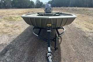 Slide: The Image of 2025 Tracker Grizzly 2072 CC boat on trailer, parked on gravel path. - 12