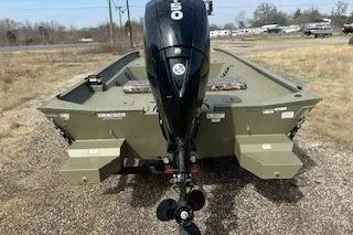 Slide: The Image of 2025 Tracker Grizzly 2072 CC boat with outboard motor, parked on gravel. - 2