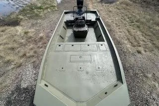 Slide: The Image of 2025 Tracker Grizzly 2072 CC boat on gravel near water, top view. - 4