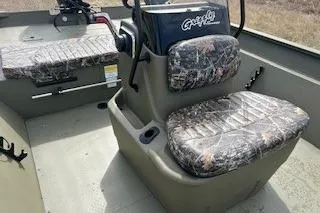 Slide: The Image of 2025 Tracker Grizzly 2072 CC boat interior with camo seats and steering console. - 6
