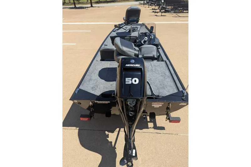 Slide: The Image of 2025 Tracker Bass Tracker Classic XL boat with Mercury 50 engine, parked on pavement. - 13