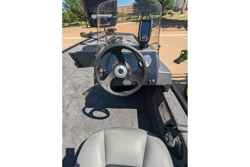 Slide: The Image of 2025 Tracker Bass Tracker Classic XL boat dashboard with steering wheel and navigation system. - 14