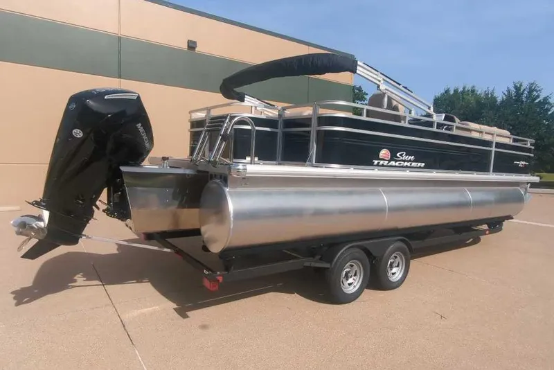 Slide: The Image of 2025 Sun Tracker Sportfish 24 XP3 pontoon boat on trailer, outdoor setting. - 17