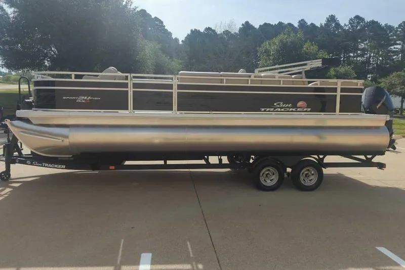Slide: The Image of 2025 Sun Tracker Sportfish 24 XP3 pontoon boat on trailer, parked outdoors. - 4