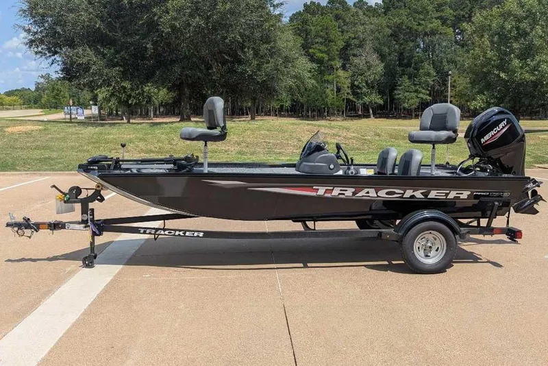 Slide: The Image of 2026 Tracker Pro 170 boat on trailer, parked outdoors with trees in background. - 4