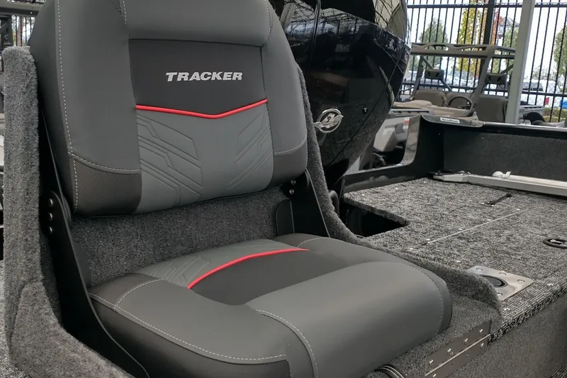 Slide: The Image of 2026 Tracker Pro Guide V-175 Combo boat seat, gray with red accents, in showroom. - 5