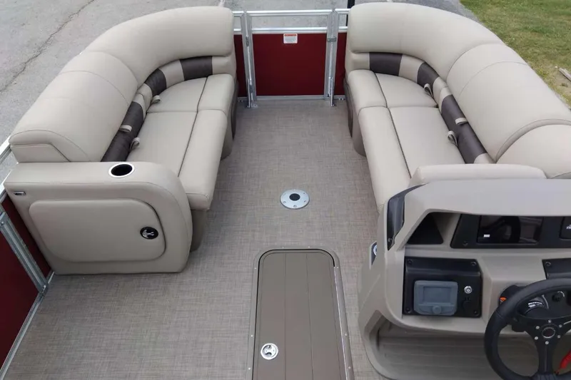 Slide: The Image of 2025 Sun Tracker Party Barge 22 RF XP3 interior with beige seating and steering console. - 4