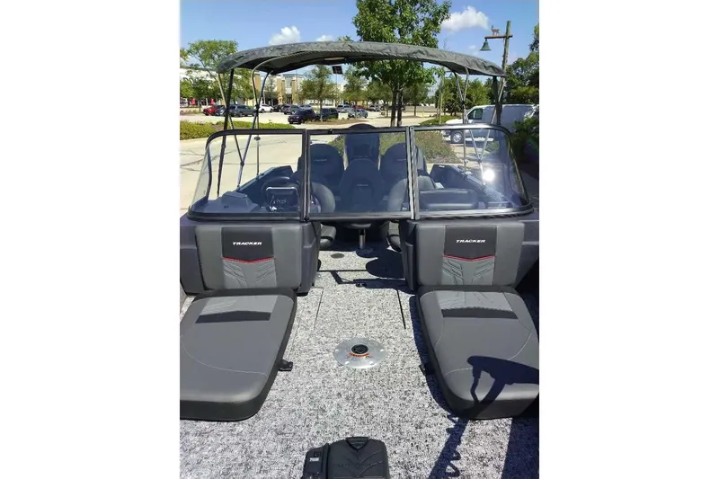 Slide: The Image of 2026 Tracker Pro Guide V-175 Combo boat with seating and canopy in a parking area. - 2