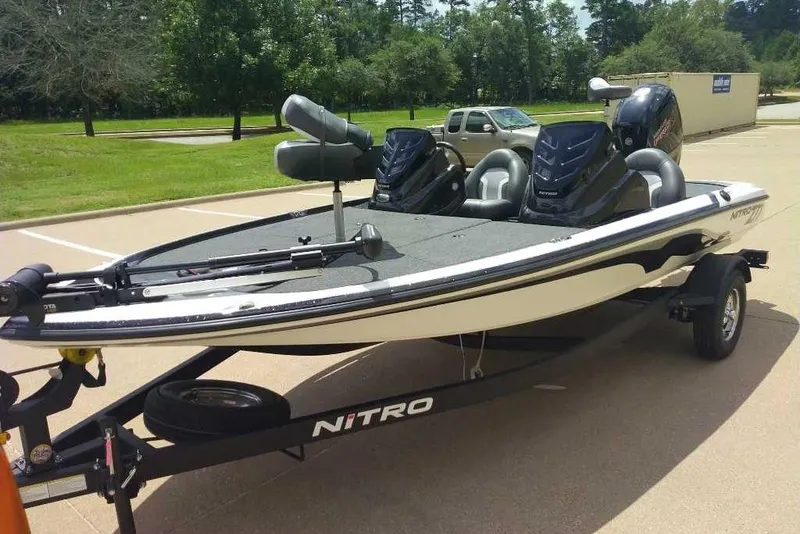 Slide: The Image of 2025 Nitro Z17 boat on trailer in parking lot, featuring dual seats and motors. - 2