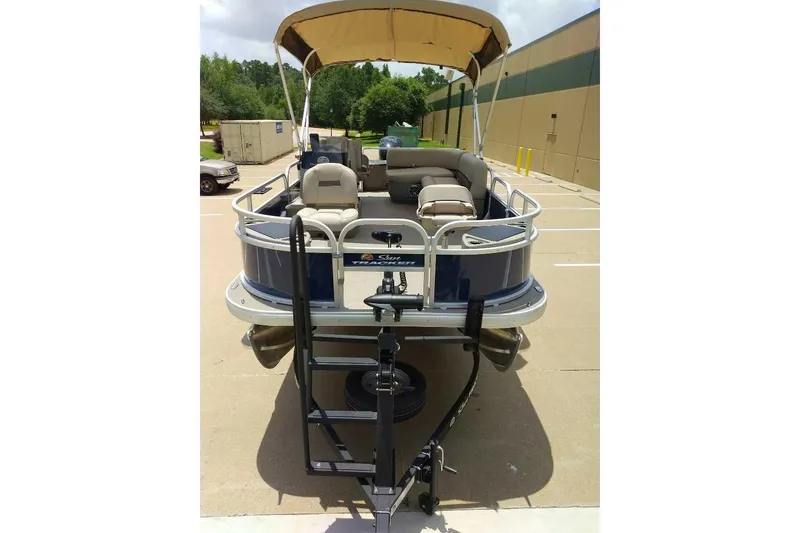 Slide: The Image of 2025 Sun Tracker Bass Buggy 18 DLX pontoon boat with canopy in parking lot. - 6