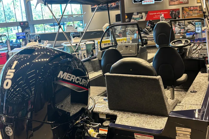 Slide: The Image of 2026 Tracker Pro Guide V-175 Combo boat with Mercury 150 engine in showroom. - 2