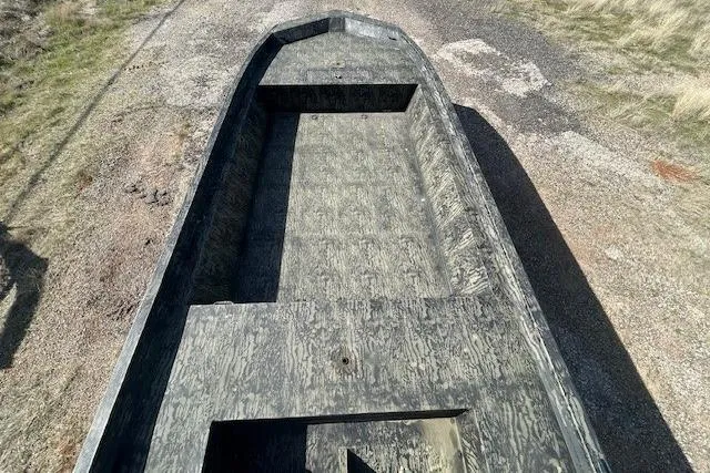 Slide: The Image of 2025 Tracker Grizzly 1860 Utility boat on gravel path, showcasing spacious interior design. - 3