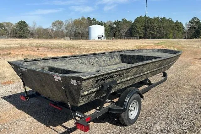 Slide: The Image of 2025 Tracker Grizzly 1860 Utility boat on trailer in rural setting. - 4