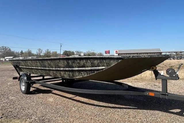 Slide: The Image of 2025 Tracker Grizzly 1860 Utility boat on trailer, parked outdoors under clear blue sky. - 9