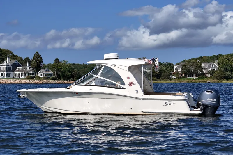 Slide: The Image of 2016 Scout 275 Dorado boat on water, scenic coastal background. - 2