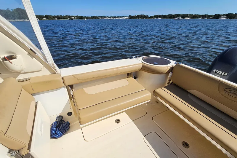 Slide: The Image of 2016 Scout 275 Dorado boat interior with tan seating, on a calm blue lake. - 28