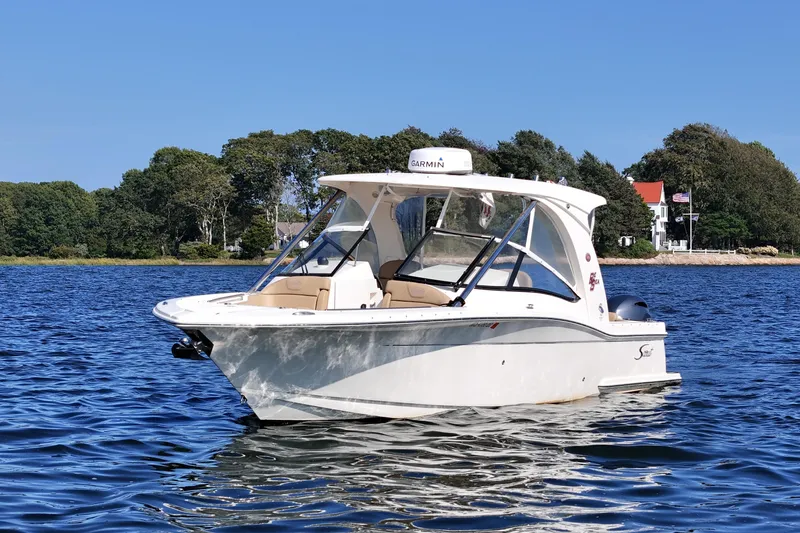 Slide: The Image of 2016 Scout 275 Dorado boat on calm water with scenic shoreline background. - 4