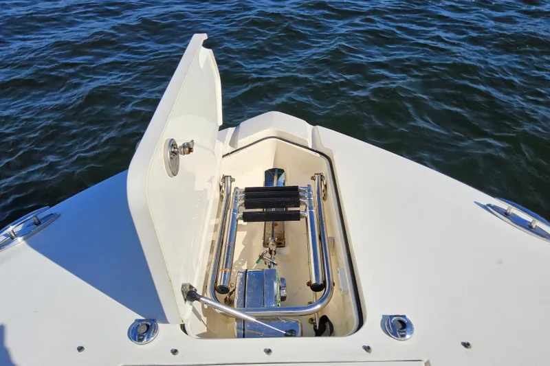 Slide: The Image of Open hatch on 2016 Scout 275 Dorado boat, revealing storage compartment, with ocean background. - 9