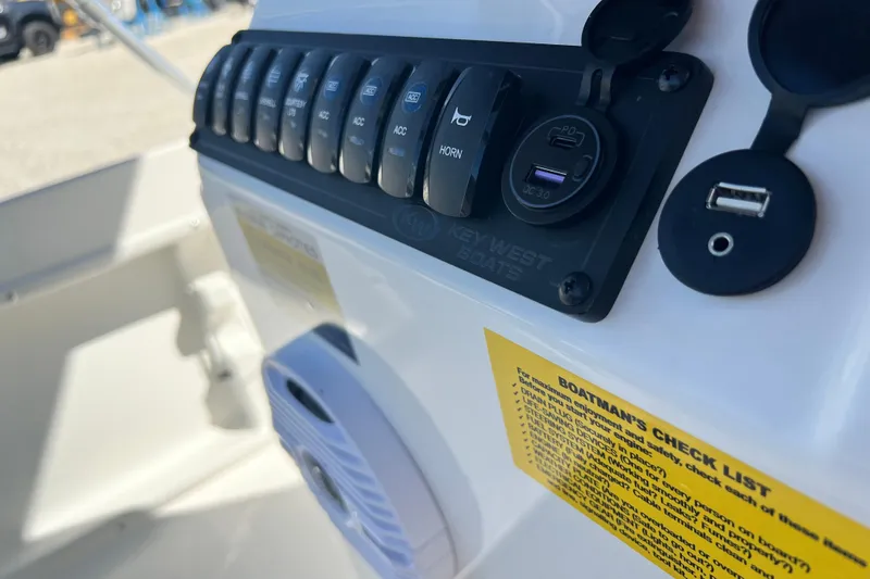 Slide: The Image of 2026 Key West 1720 Center Console boat dashboard with switches and USB ports. - 22