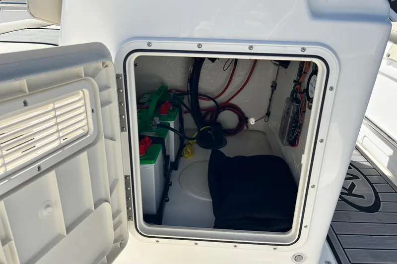 Slide: The Image of Open storage compartment on 2026 Key West 1720 Center Console boat, showing batteries and wiring. - 28