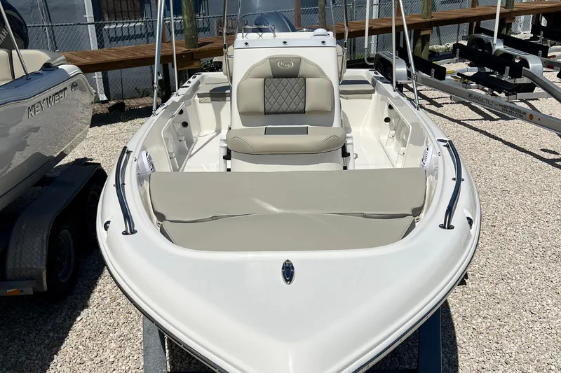 Slide: The Image of 2026 Key West 1720 Center Console boat with beige seating, parked on gravel. - 4