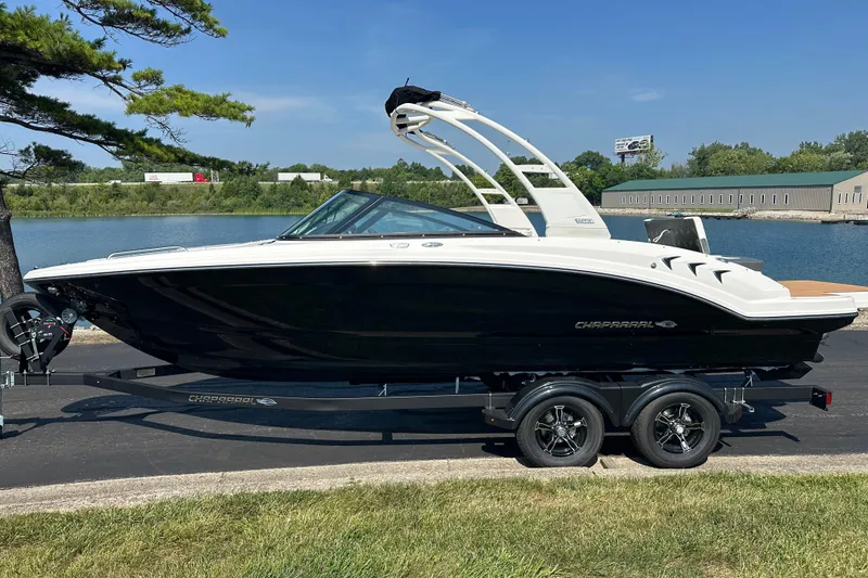 The Image of 2026 CHAPPARRAL 23 SSi boat on trailer by a lake, under clear blue sky. - 0