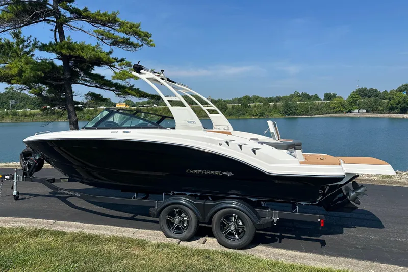 Slide: The Image of 2026 CHAPPARRAL 23 SSi boat on trailer by a lake, under clear blue sky. - 1
