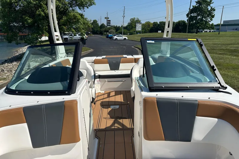 Slide: The Image of 2026 CHAPPARRAL 23 SSi boat interior with tan and gray seating, open windshield. - 16