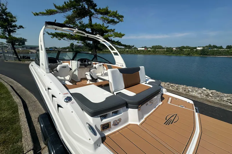 Slide: The Image of 2026 CHAPPARRAL 23 SSi boat docked by a scenic lakeside with modern seating. - 5