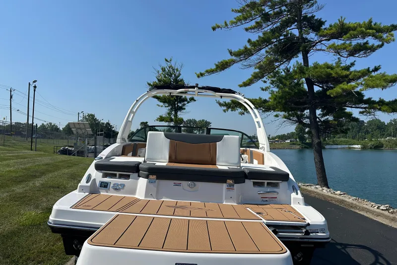 Slide: The Image of 2026 CHAPPARRAL 23 SSi boat by a lake, showcasing rear deck and seating. - 6