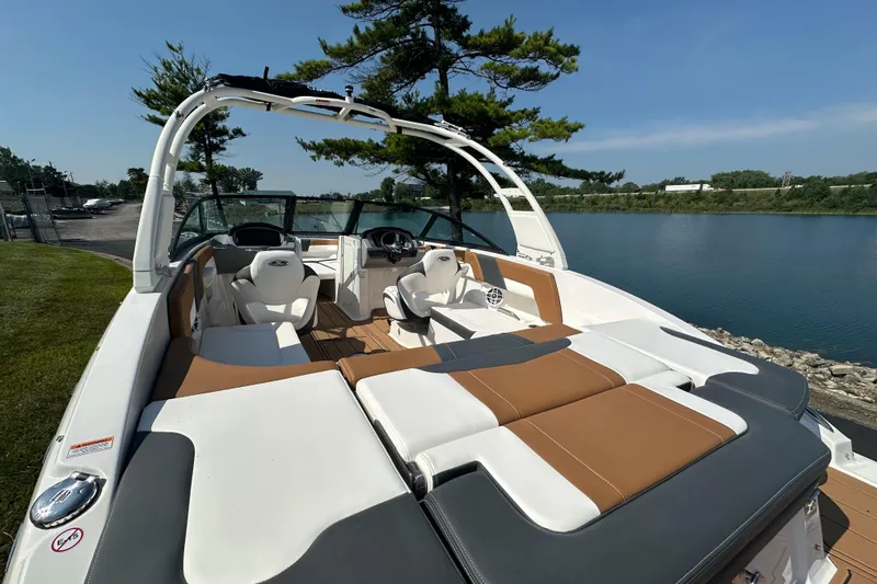 Slide: The Image of 2026 CHAPPARRAL 23 SSi boat interior with seating, near a serene lake. - 9