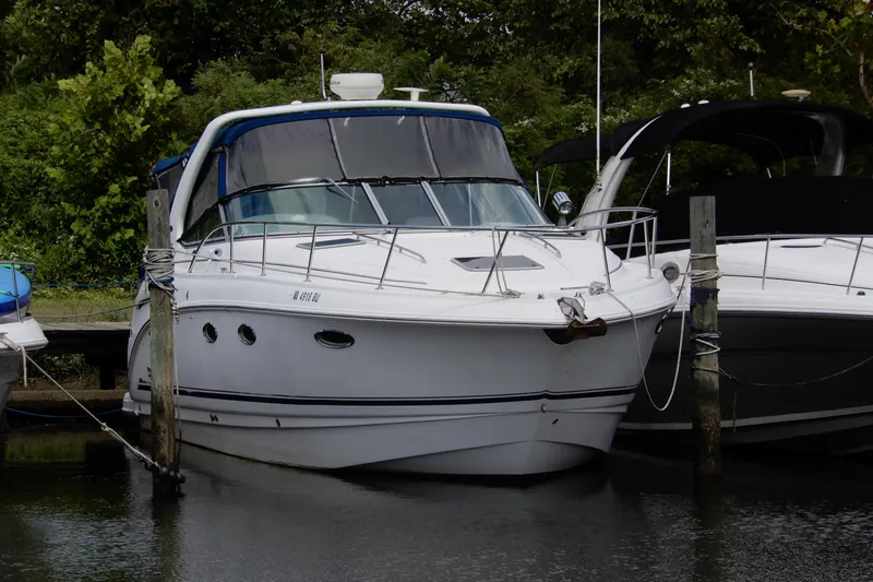 The Image of Chaparral Signature 320, 2002 model, docked at a marina with lush greenery. - 0