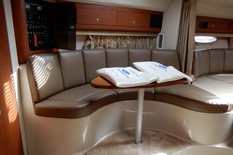 Slide: The Image of 2002 Chaparral Signature 320 interior with curved seating and wooden table. - 27