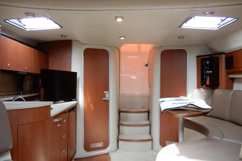 Slide: The Image of 2002 Chaparral Signature 320 interior with modern amenities, wood finishes, and cozy seating area. - 29